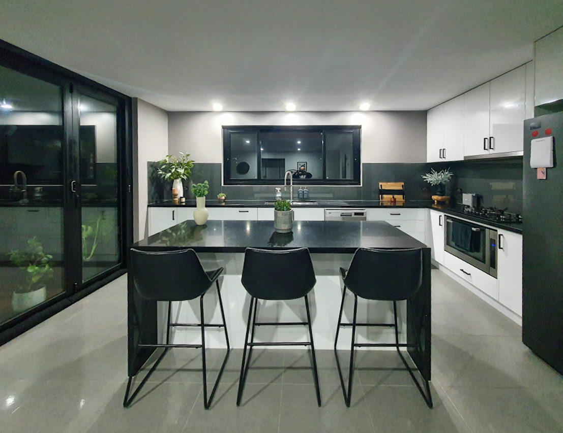 Repainted kitchen with white cabinetry and dark benchtops