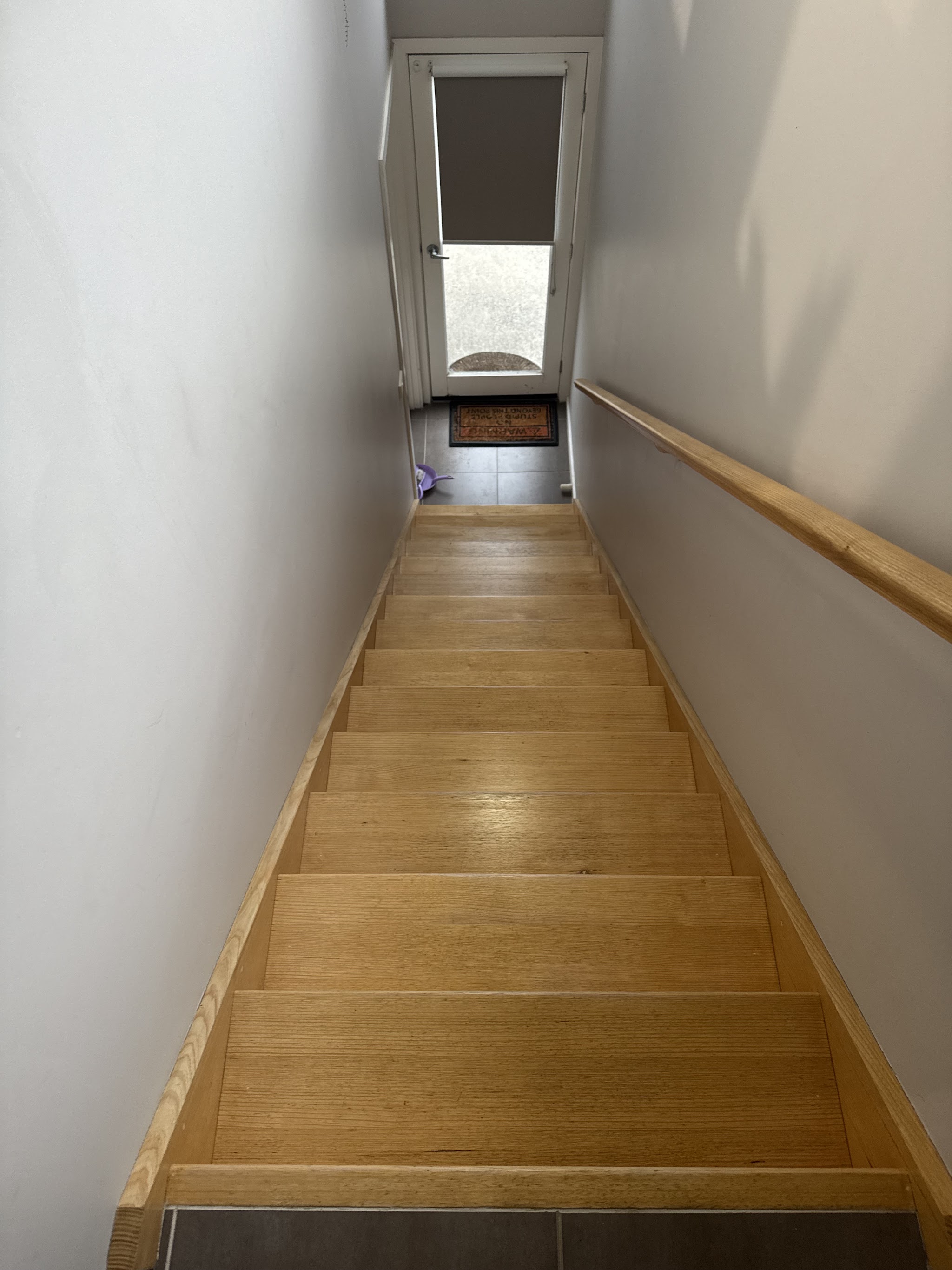 Repainted interior stairwell with white walls and timber stairs